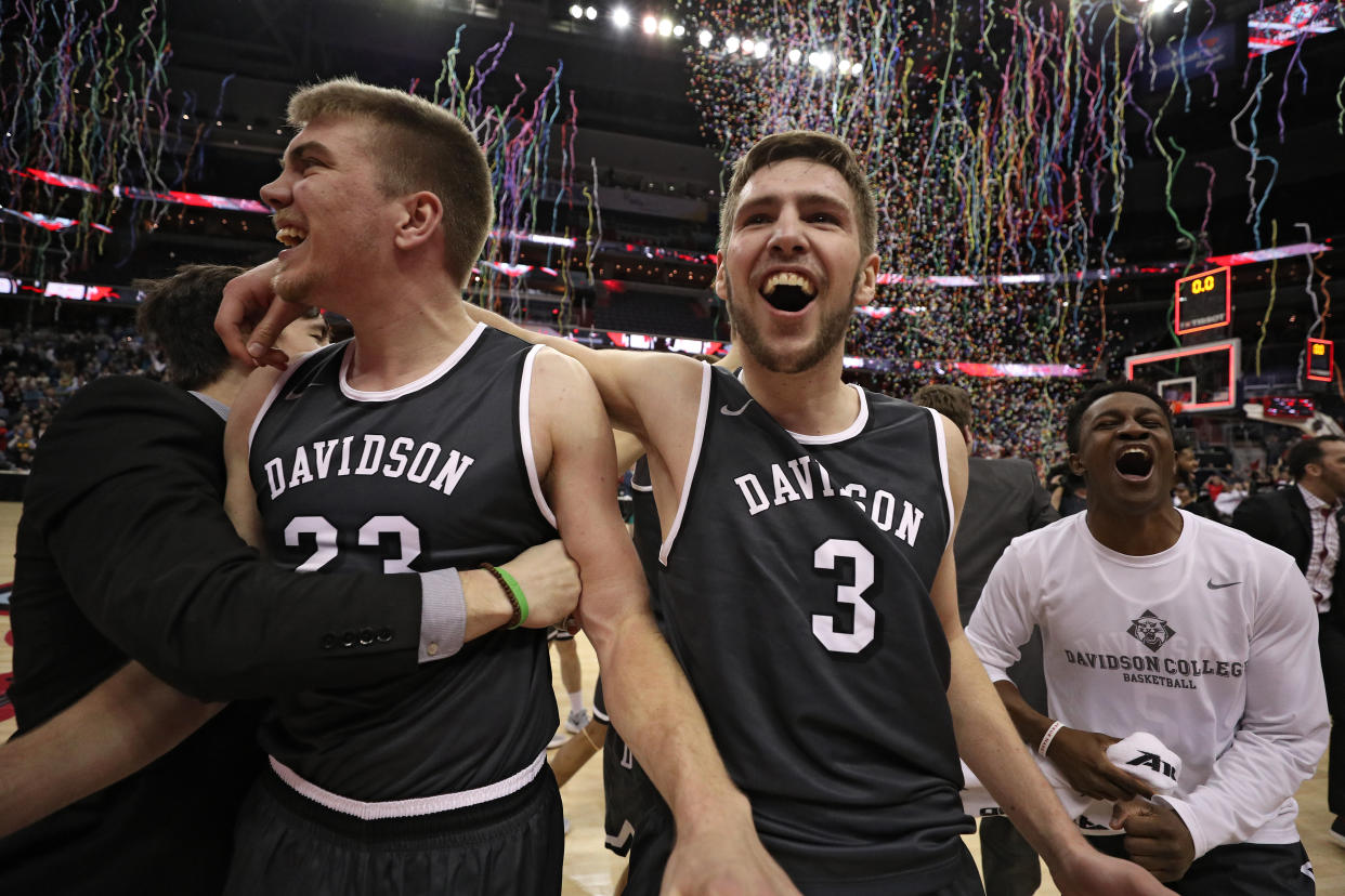 Davidson’s Peyton Aldridge (left) and Jon Axel Gudmundsson (center) celebrate securing an automatic bid to the 2018 NCAA tournament. (Getty)