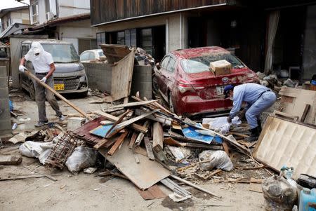 Local residents try to clear mud and debris at a flood affected area in Mabi town in Kurashiki, Okayama Prefecture, July 13, 2018. REUTERS/Issei Kato