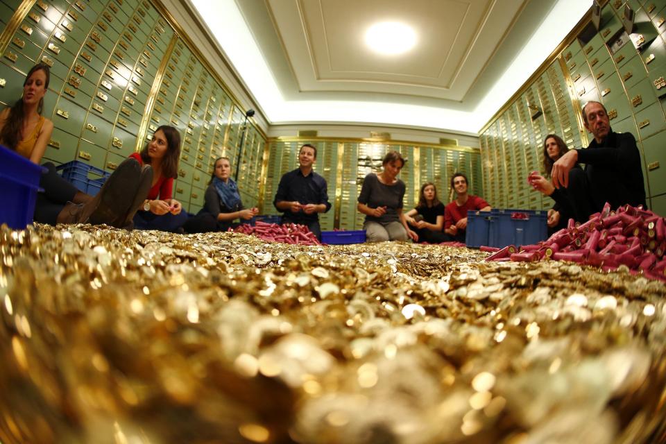 Committee members for 'Grundeinkommen' open rolls of five cent coins in the old vault of the former Schweizerische Volksbank in Basel