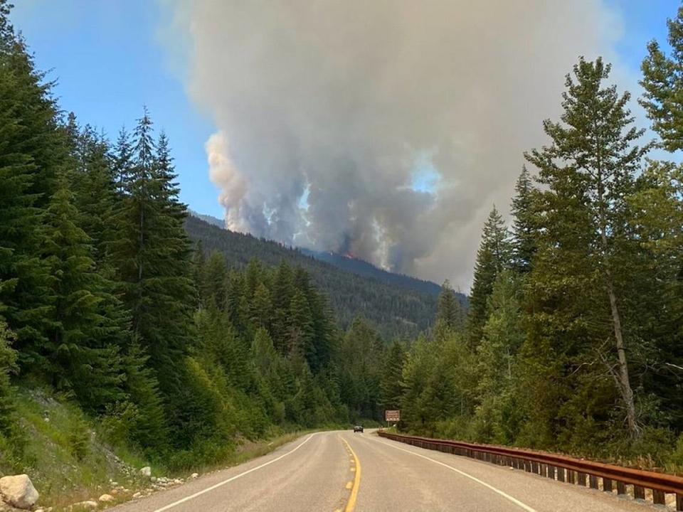 Smoke rises from a fire west of Winthrop, Wash., along Highway 20 on Monday, July 12, 2021.