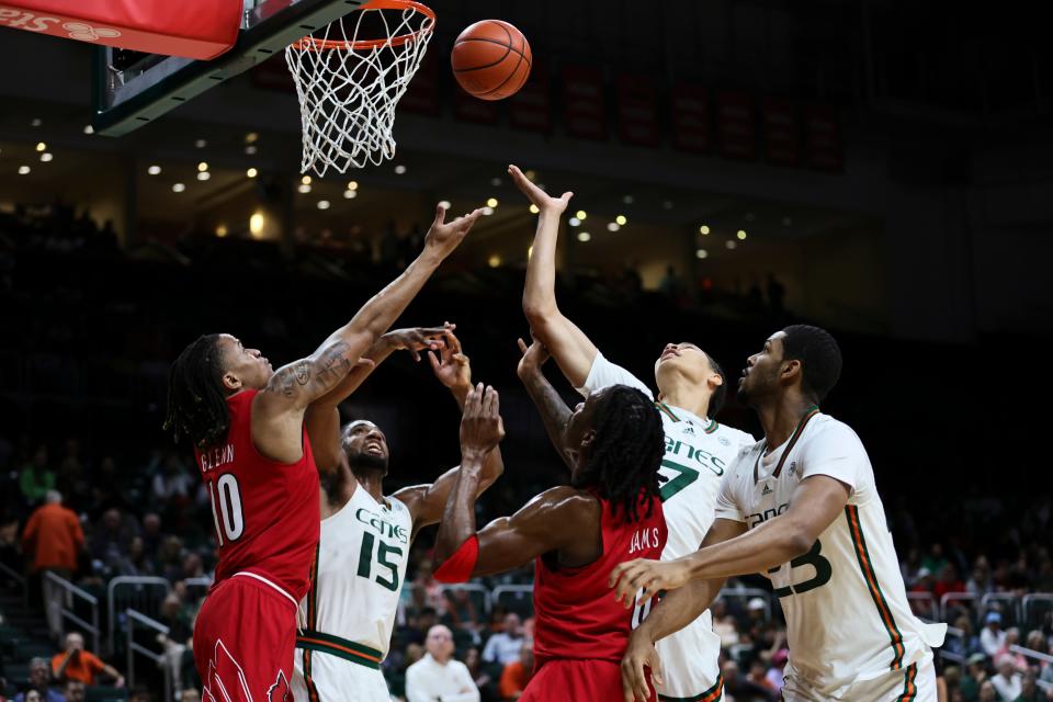 Jan 10, 2024; Coral Gables, Florida, USA; Louisville Cardinals forward Kaleb Glenn (10) and guard Mike James (0) battle for a rebound against Miami Hurricanes forward Norchad Omier (15), guard Kyshawn George (7) and forward AJ Casey (23), during the first half at Watsco Center. Mandatory Credit: Sam Navarro-USA TODAY Sports