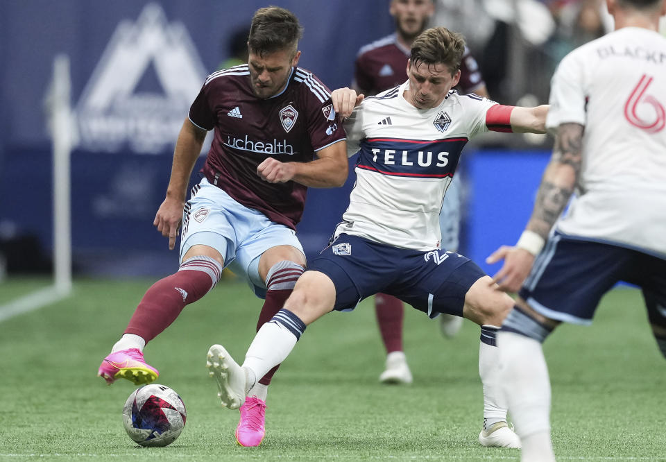 Colorado Rapids' Diego Rubio, left, and Vancouver Whitecaps' Ryan Gauld vie for the ball during the first half of an MLS soccer match Saturday, April 29, 2023, in Vancouver, British Columbia. (Darryl Dyck/The Canadian Press via AP)
