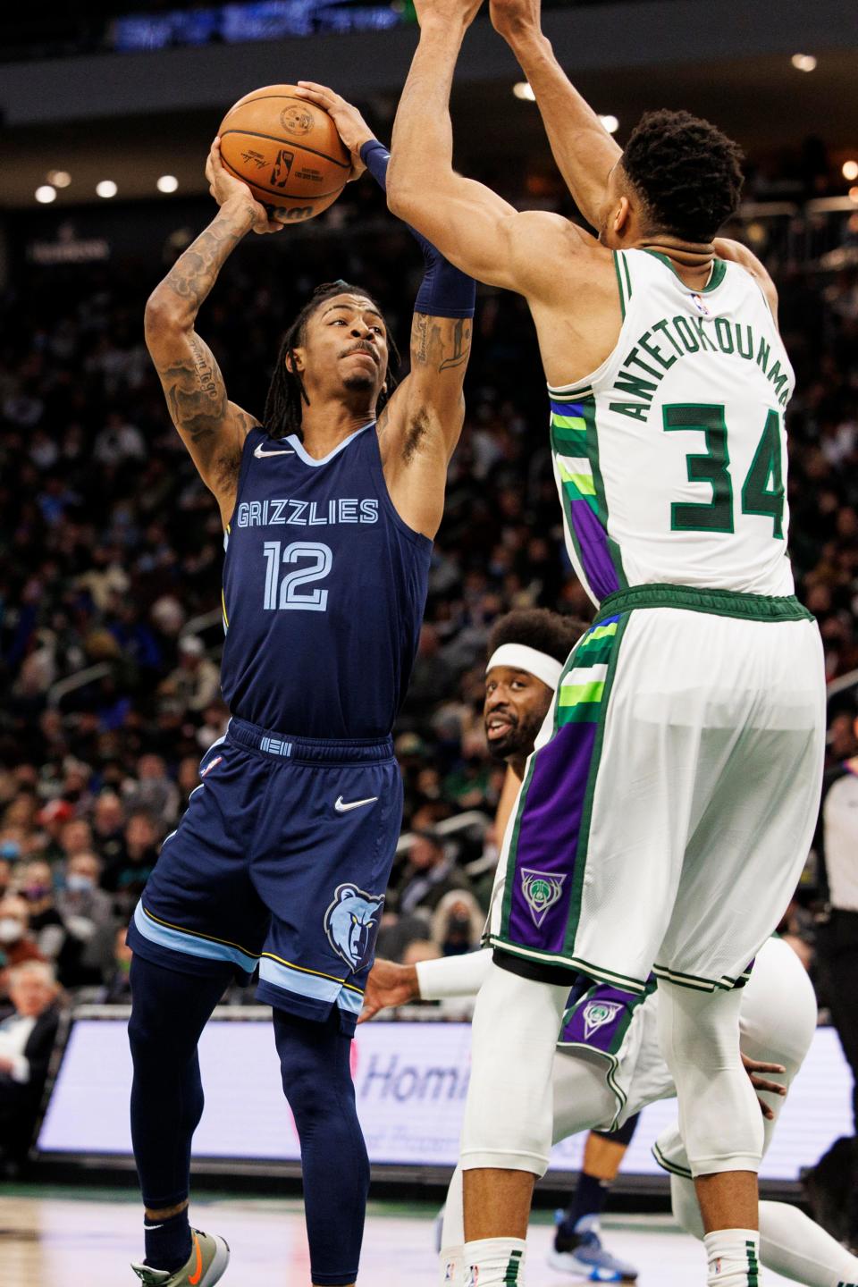 Jan 19, 2022; Milwaukee, Wisconsin, USA; Memphis Grizzlies guard Ja Morant (12) drives for a shot against Milwaukee Bucks forward Giannis Antetokounmpo (34) during the second quarter at Fiserv Forum. Mandatory Credit: Jeff Hanisch-USA TODAY Sports