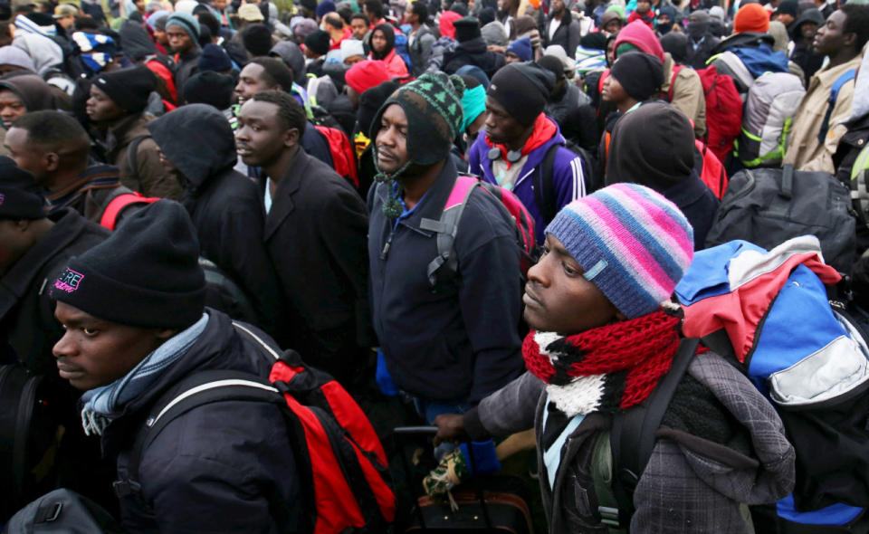 Residents of the camp queue to get on to coaches to take them across France. 