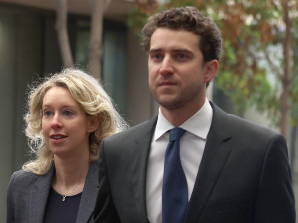 Former Theranos CEO Elizabeth Holmes (C) arrives at federal court with her father Christian Holmes (L) and partner Billy Evans (R) on October 17, 2022 in San Jose, California.