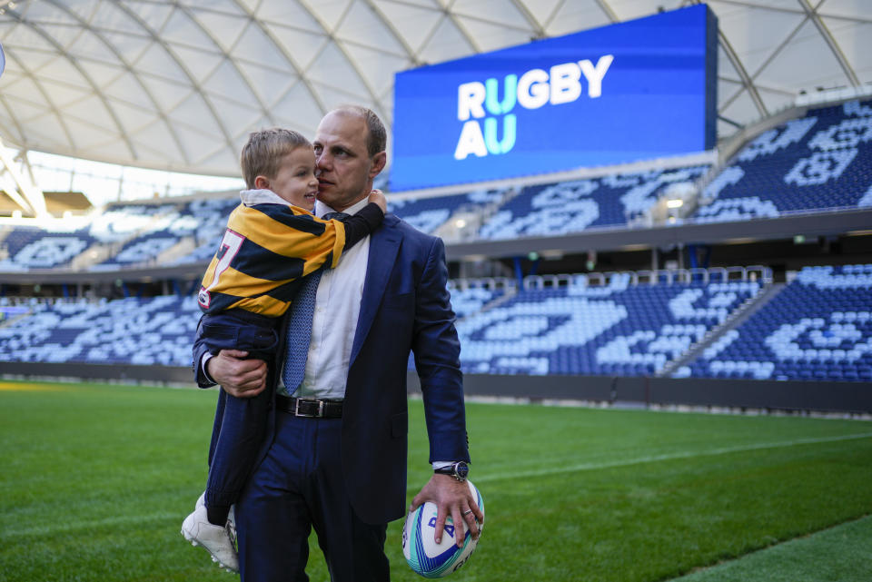 Rugby Australia's new Chief Executive Phil Waugh poses for a portrait with his son Arthur at the Sydney Football Stadium in Sydney, Australia, Tuesday, June 6, 2023. Waugh becomes the first Wallaby to occupy the role, having earned 79 caps. (AP Photo/Mark Baker)