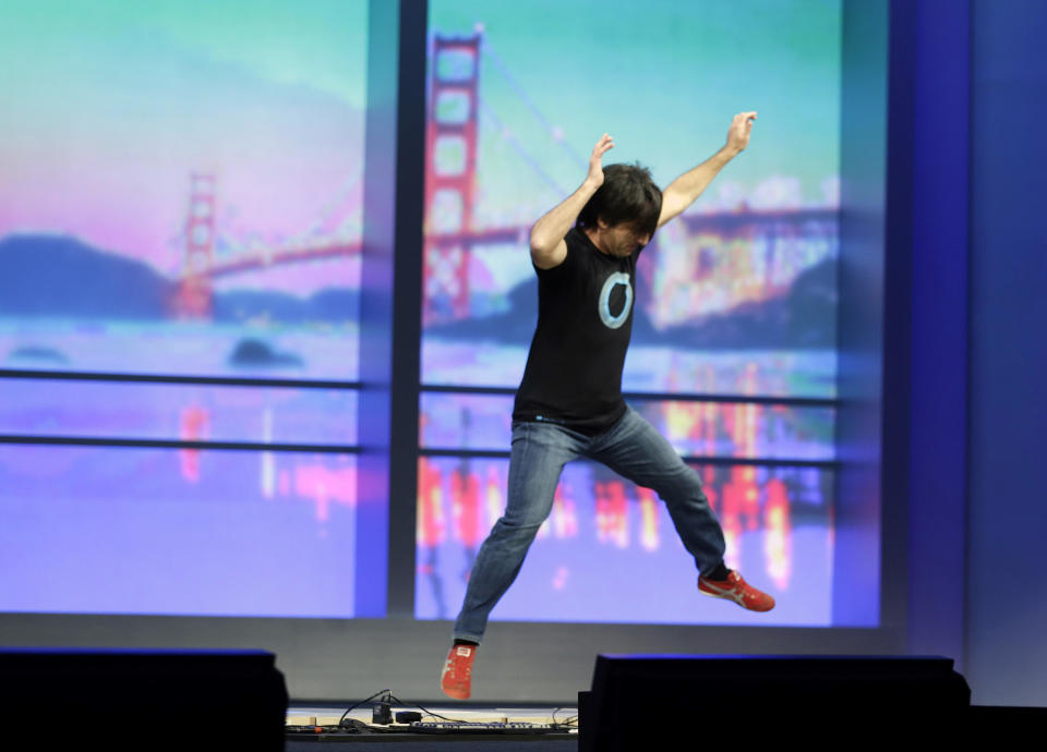 Microsoft corporate vice president Joe Belfiore, of the Operating Systems Group ,uses his feet to play a piano connected to an Xbox during the keynote address of the Build Conference Wednesday, April 2, 2014, in San Francisco. Microsoft kicked off its annual conference for software developers, with new updates to the Windows 8 operating system and upcoming features for Windows Phone and Xbox. (AP Photo/Eric Risberg)