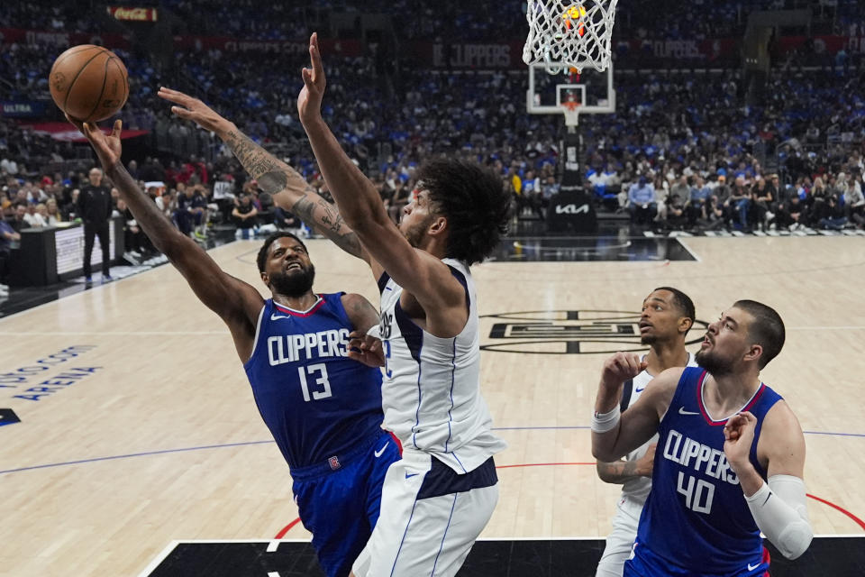 LA Clippers forward Paul George (13) shoots against Dallas Mavericks center Dereck Lively II (2) during the first half of Game 1 of an NBA basketball first-round playoff series in Los Angeles, Sunday, April 21, 2024. (AP Photo/Ashley Landis)