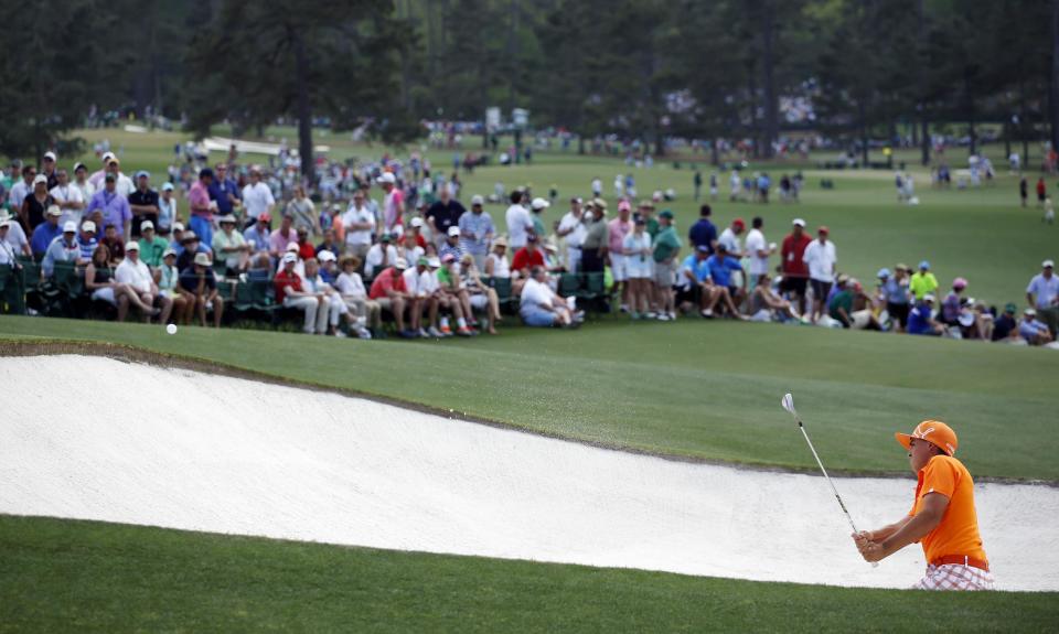 Rickie Fowler hits out of a bunker on the ninth hole during the fourth round of the Masters golf tournament Sunday, April 13, 2014, in Augusta, Ga. (AP Photo/Matt Slocum)