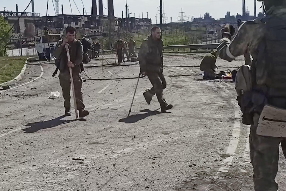 In this photo taken from a video released by the Russian Defense Ministry Press Service on Wednesday, May 18, 2022, shows Ukrainian servicemen as they leave the besieged Azovstal steel plant in Mariupol, Ukraine. (Russian Defense Ministry Press Service via AP)