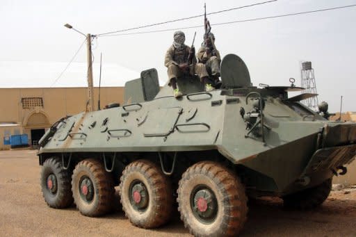 Movement for Oneness and Jihad in West Africa (MUJAO) fighters stand guard on a tank abandoned by the Malian Army near Gao airport in August 2012. Dozen of Algerian jihadists have arrived in the Malian city of Timbuktu to support armed Islamist groups who are imposing an increasingly brutal version of sharia law in the vast northern areas under their control, security sources said Sunday