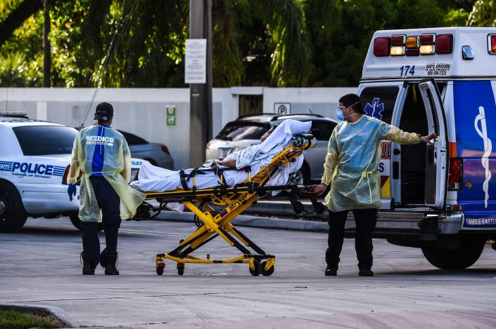 Medics transfer a patient on a stretcher from an ambulance outside of Emergency at Coral Gables Hospital where Coronavirus patients are treated in Coral Gables near Miami, on July 30, 2020.(Chandan Khanna/AFP via Getty Images)