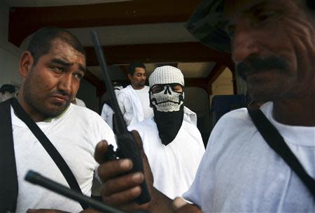 Vigilantes stand outside the municipality after entering the town of Nueva Italia January 12, 2014. REUTERS/Alan Ortega/Files