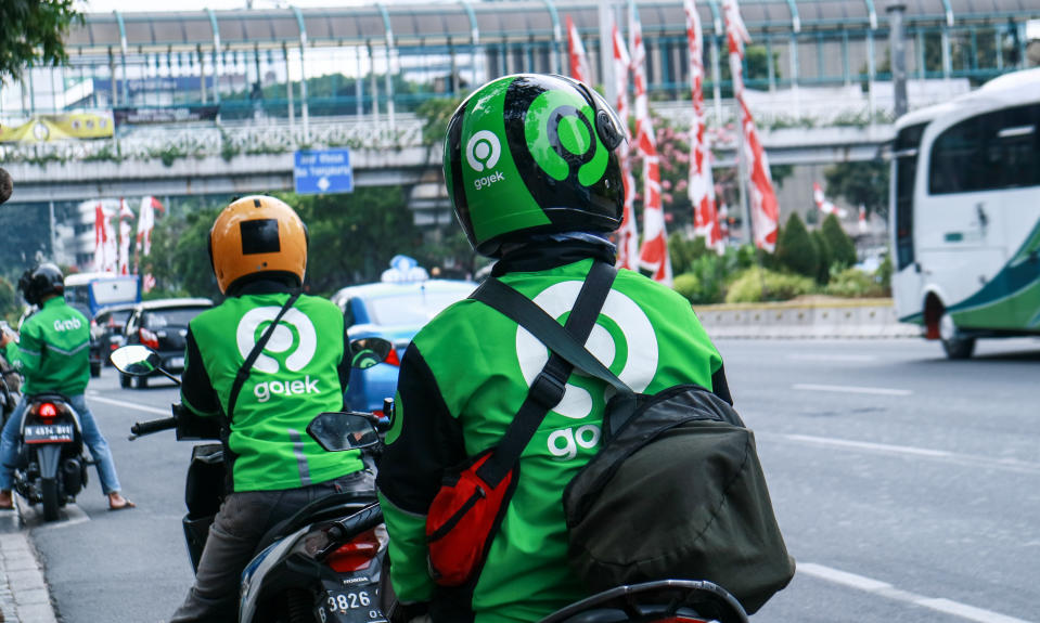 Jakarta, Indonesia - August 28, 2019: Driver of Gojek, motorcycle taxi, waiting passenger on Jalan MH Thamrin, Central Jakarta.