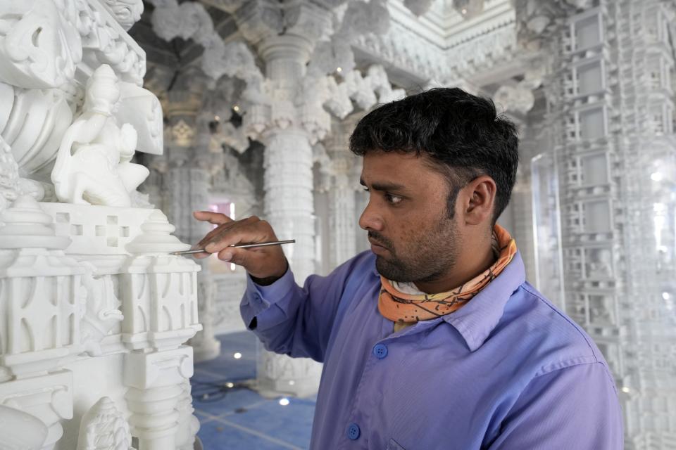 A worker does the final touches on a marble pillar of the first stone-built Hindu temple in Abu Mureikha, 40 kms, 25 miles, northeast of Abu Dhabi, United Arab Emirates, Monday, Feb. 12, 2024. The soon-to-open BAPS Hindu Mandir signals just how far the United Arab Emirates has come in acknowledging the different faiths of its expatriate community, long dominated by Indians who power life across its construction sites and boardrooms. (AP Photo/Kamran Jebreili)