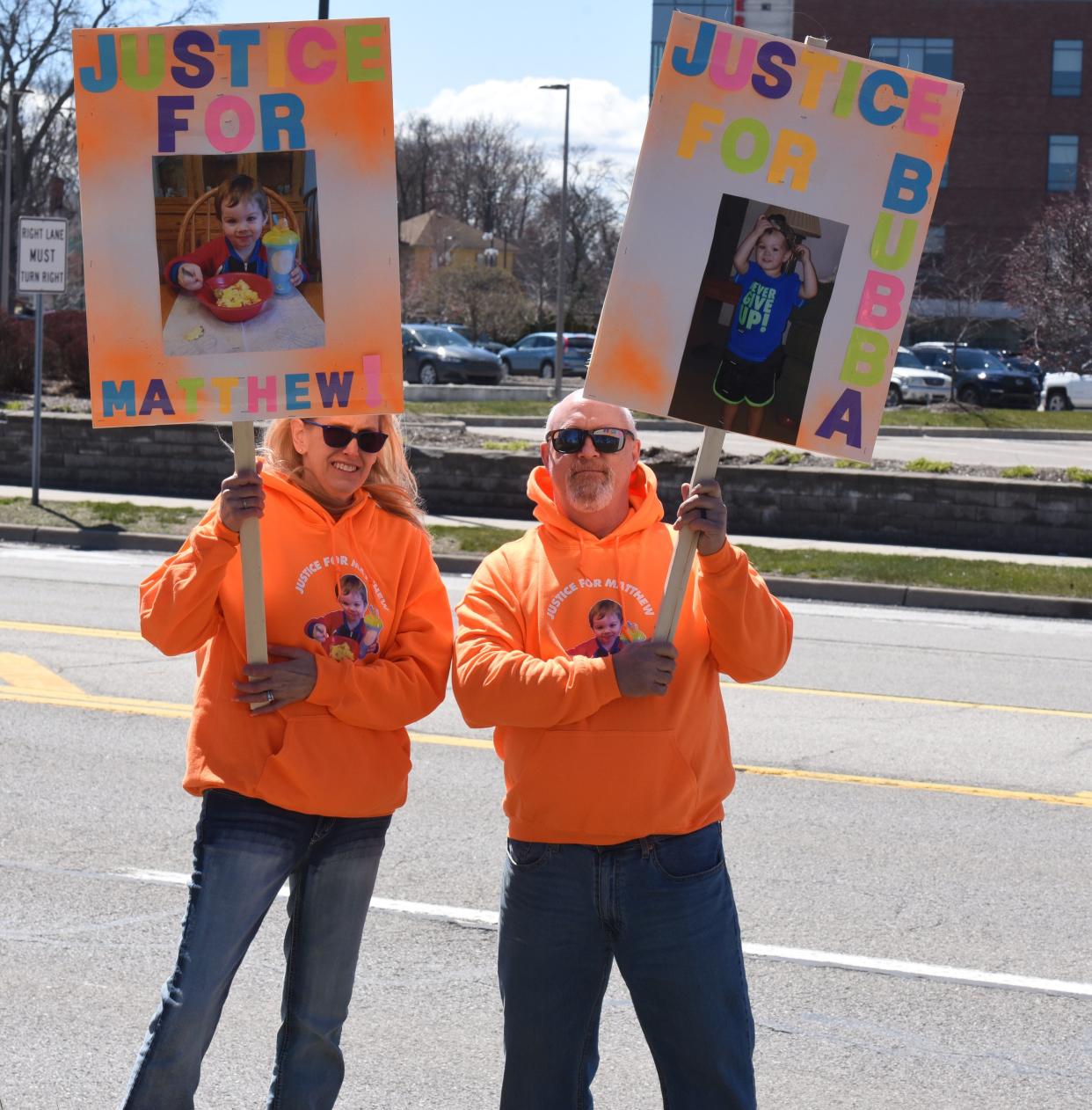 Amy and David Maison hold their signs along Pine Grove Avenue asking passersby to remember their grandson Matthew Maison on April 6, 2024.