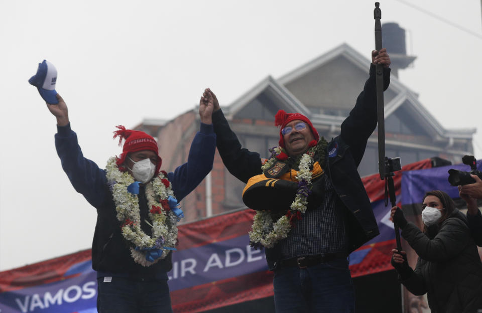 Luis Arce, center, Bolivian presidential candidate for the Movement Towards Socialism Party, MAS, right and running mate David Choquehuanca hold hands during their closing campaign rally for the upcoming Oct. 18, presidential elections, in El Alto, Bolivia, Wednesday, Oct. 14, 2020. (AP Photo/Juan Karita)