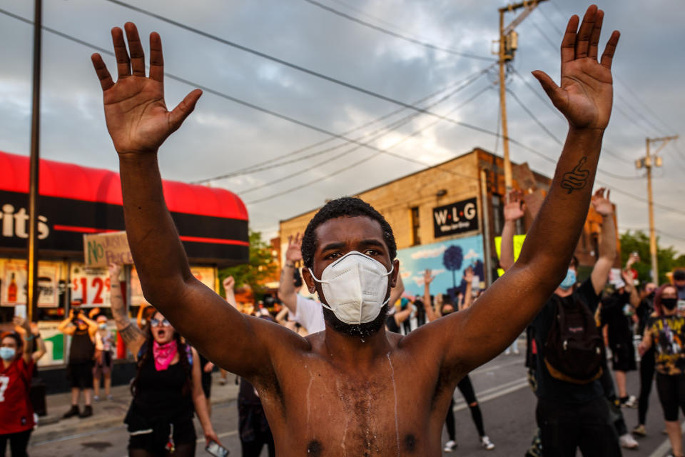 A protester wearing a mask holds up his hands during a demonstration outside the 3rd precinct on May 27. | Kerem Yücel—AFP/Getty Images