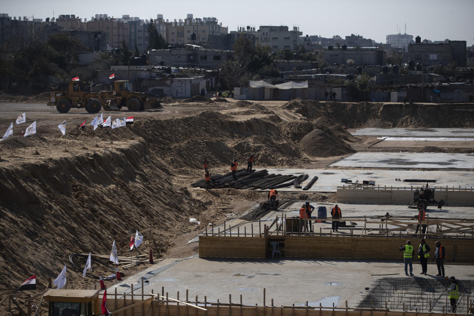 Laborers work on concrete slab foundations for one of three Egyptian-funded housing complexes in the Gaza Strip, in the town of Beit Lahiya, northern Gaza, Jan. 25, 2022. After years of working behind the scenes as a mediator, Egypt is taking on a much larger and more public role in Gaza. In the months since it brokered a Gaza cease-fire last May, Egypt has sent crews to clear rubbled and promised to build vast new apartment complexes, and billboards of its president Abdel-Fattah el-Sissi, are a common sight. (AP Photo/Khalil Hamra)