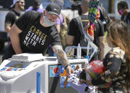 In this photo taken Friday, June 5, 2020, Minnesota Vikings NFL football player Kyle Rudolph hands out ice cream to children waiting in line at the "Change Starts with Me" food and household supply giveaway outside a Cub Foods store in Minneapolis. George Floyd was killed less than three miles from the stadium where the Minnesota Vikings play, so this global unrest over racial relations and justice hit awfully close to home for the team. (Brian Peterson/Star Tribune via AP)