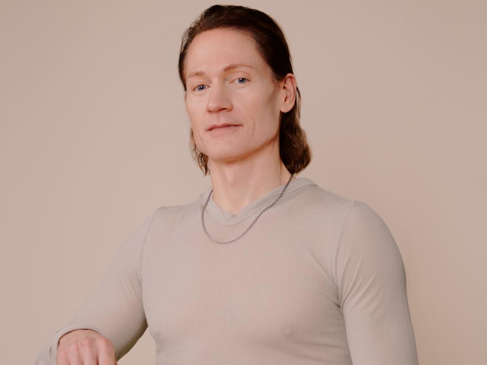 Bryan Johnson wearing a beige shirt in front of a beige background.