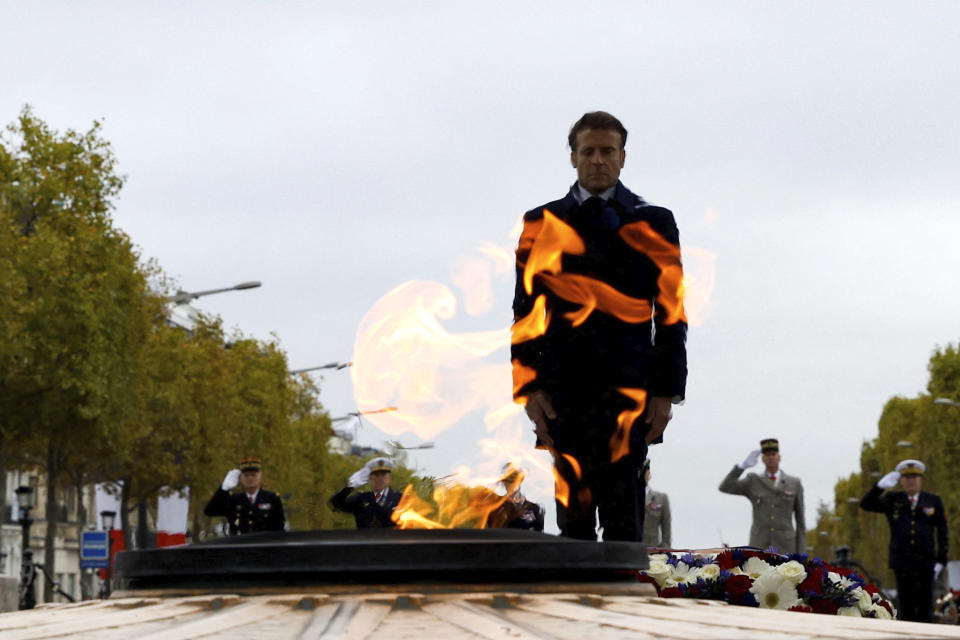 French President Emmanuel Macron stands at the Tomb of the Unknown Soldier during a ceremony at the Arc de Triomphe, as part of the commemorations marking the 104th anniversary of the Nov. 11, 1918 Armistice, ending World War I, Friday, Nov. 11, 2022 in Paris,. (Gonzalo Fuentes/Pool via AP)