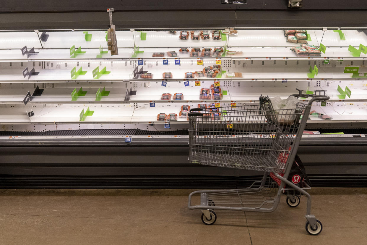 A empty shopping cart sits in front of early empty shelves of meat at a supermarket in Washington, Tuesday, Jan. 4, 2022. (AP Photo/Andrew Harnik)