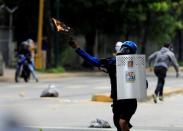 A demonstrator throws a petrol bomb while clashing with riot security forces during a rally against Venezuela's President Nicolas Maduro's government in Caracas, Venezuela, July 22, 2017. REUTERS/Marco Bello