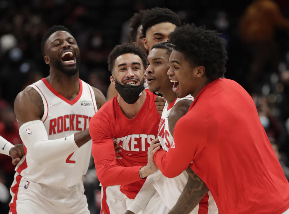 Houston Rockets' Kevin Porter Jr., second from right, celebrates with teammates after making the game-winning 3-point shot in the team's NBA basketball game against the Washington Wizards, Wednesday, Jan. 5, 2022, in Washington. (AP Photo/Luis M. Alvarez)