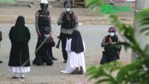 Nun Sister Ann Rose Nu Tawng kneels before police officers to ask security forces to refrain from violence against children and residents in Myitkyina, Myanmar
