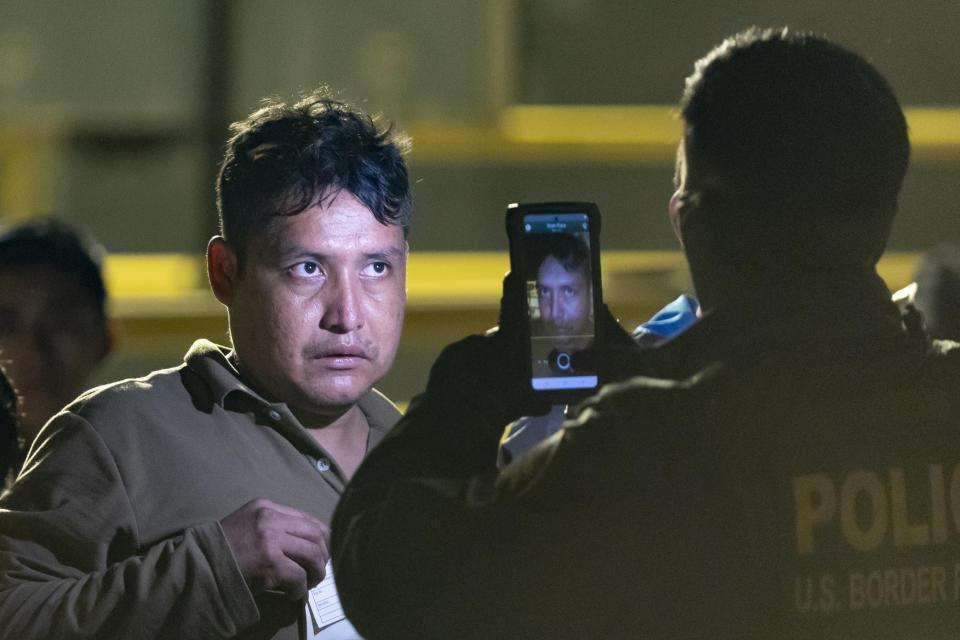 A Border Patrol officer takes a photo of a migrant in between the border walls separating Tijuana, Mexico, and San Diego, Tuesday, May 7, 2024, in San Diego. San Diego became the busiest corridor for illegal crossings in April, according to U.S. figures, the fifth region to hold that title in two years in a sign of how quickly migration routes are changing. (AP Photo/Ryan Sun)