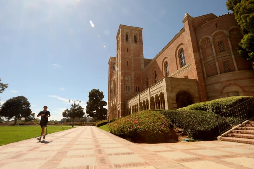 LOS ANGELES, CA - AUGUST 05, 2020 - - A lone jogger runs past Royce Hall on a nearly empty UCLA campus in Los Angeles on August 13, 2020. The empty campus is a preview of what the Fall semester will look like during the coronavirus pandemic. Most classes, much like the summer classes, will be held online at the university. (Genaro Molina / Los Angeles Times)