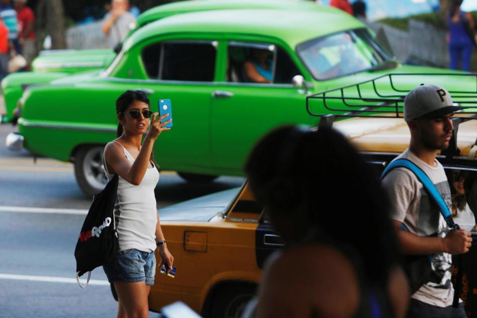 A woman uses her phone at an internet hotspot in Havana, Cuba: REUTERS