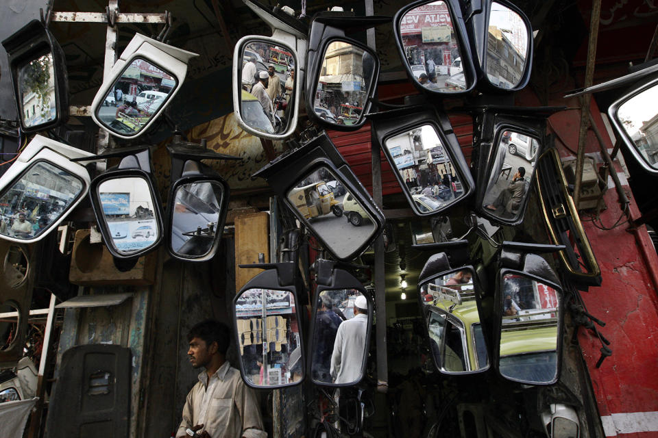 <p>Pakistani pedestrians and vehicles moving on a road are reflected in mirrors displayed for sale outside a mechanic shop, in Rawalpindi, Pakistan, May 23, 2013. (Photo: Muhammed Muheisen/AP) </p>