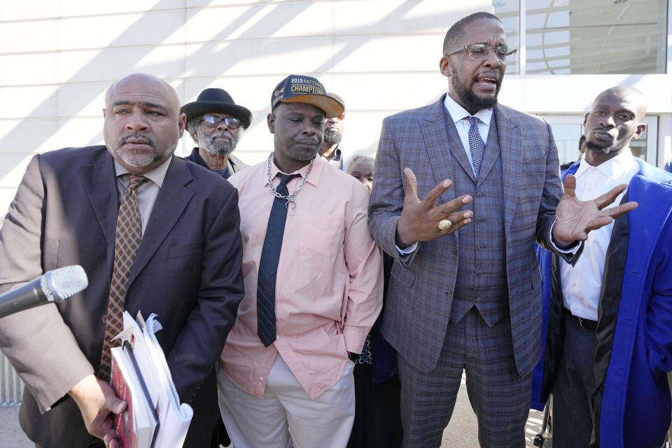 Lead civil attorney Malik Shabazz, second from right, speaks to reporters while his clients, Michael Corey Jenkins, right, and Eddie Terrell Parker, second from left, stand with their local attorney Trent Walker, outside the federal courthouse in Jackson, Miss., Tuesday, March 19, 2024, following the sentencing of the second of six former Mississippi Rankin County law enforcement officers who committed numerous acts of racially motivated, violent torture on Parker and Jenkins in 2023. (AP Photo/Rogelio V. Solis)