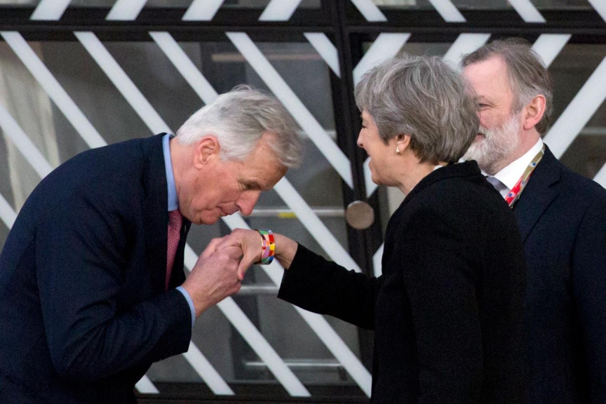 Michel Barnier plants a kiss on the hand of Theresa May: AP