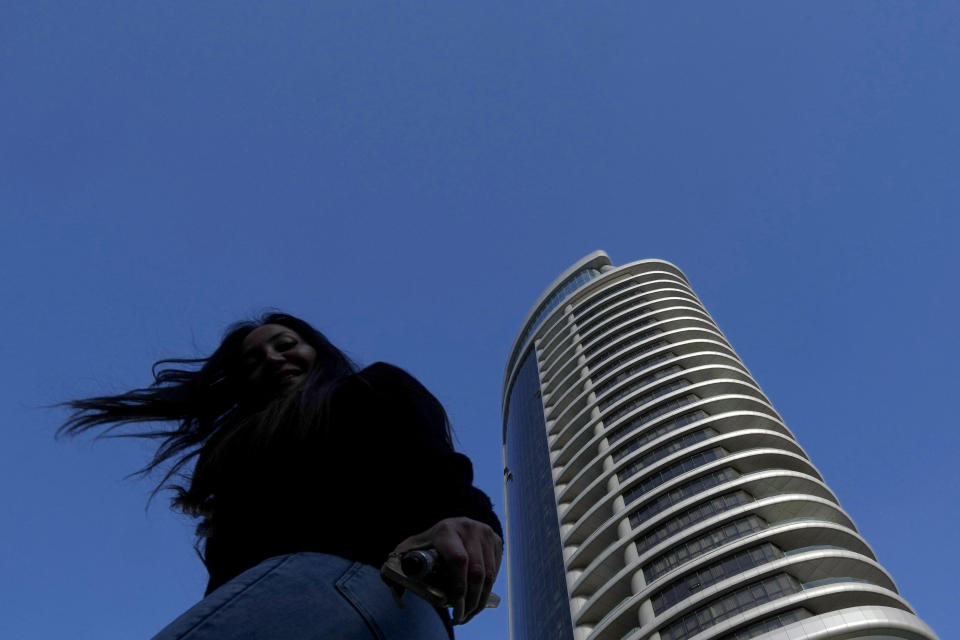 A woman reacts as she walks outside from a higher tower in central capital Nicosia, Cyprus, Wednesday, Jan. 24, 2024. Official figures show Cyprus making significant headway in weaning itself off Russian cash and business as it tries to clean up its image as a favorite destination for Moscow's money. According to the figures, the number of Russian clients using Cypriot banks has dropped 82% between 2014 up until the end of 2022. (AP Photo/Petros Karadjias)