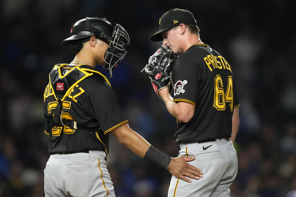 Pittsburgh Pirates catcher Endy Rodriguez talks with relief pitcher Quinn Priester during the third inning of the team's baseball game against the Chicago Cubs on Tuesday, Sept. 19, 2023, in Chicago. (AP Photo/Charles Rex Arbogast)