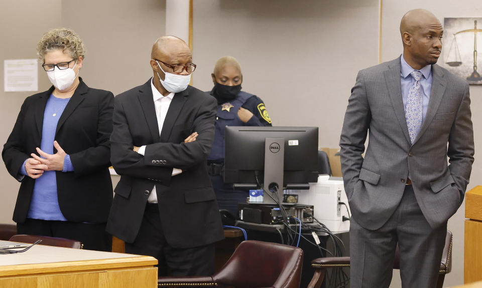 Defense attorney Kobby Warren, right, confers with the judge on behalf of his client Billy Chemirmir, center, as motions and language being sent to the jury in his capital murder trial at the Frank Crowley Courts Building in Dallas, Friday, Nov. 19, 2021. He was joined by private investigator Tonia Silva, left. Chemirmir, 48, faces life in prison without parole if convicted of capital murder for smothering Lu Thi Harris, 81, and stealing her jewelry. He is accused of killing at least 18 women in Dallas and Collin counties. (Tom Fox/The Dallas Morning News via AP, Pool)