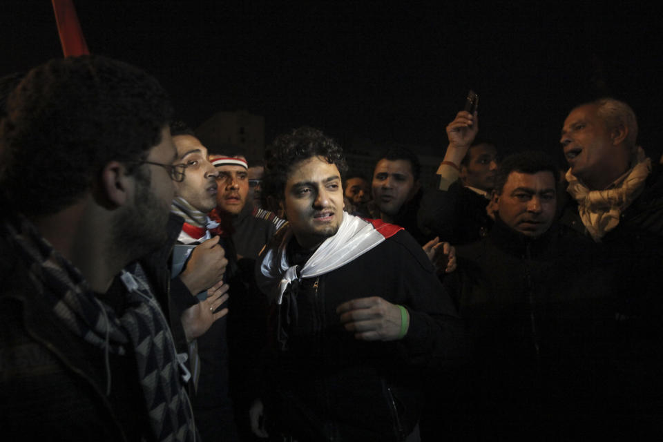 FILE - In this Feb. 10, 2011 file photo, Egyptian Wael Ghonim, center, walks into Tahrir Square after Egyptian President Hosni Mubarak's televised statement to his nation, in downtown Cairo, Egypt. Ghonim said late Thursday, Sept. 19, 2019 in a video on his twitter account that authorities raided his parents' house in Cairo and arrested his brother Hazem, whom he described as "a political person" and confiscated his parents' passports. Ghonim alleges that the Egyptian embassy in the U.S. threatened him the previous day "something will happen" if he didn't stop criticizing Egypt's government on social media. (AP Photo/Tara Todras-Whitehill)