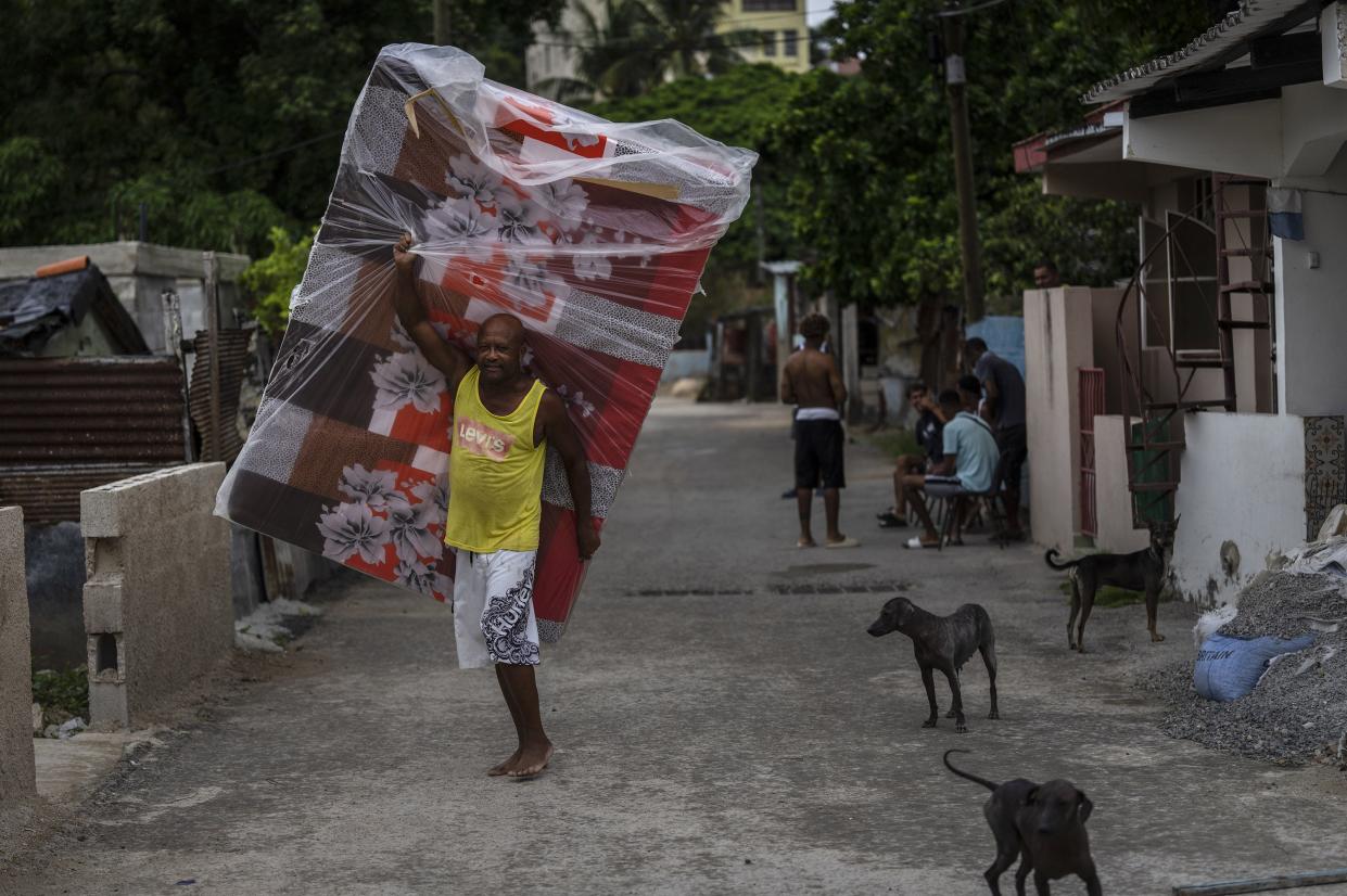 A resident of El Fanguito neighborhood carries a mattress in preparation for the arrival of Hurricane Ian, in Havana, Cuba, Monday, Sept. 26, 2022. Hurricane Ian is growing stronger as it approached the western tip of Cuba on a track to hit the west coast of Florida as a major hurricane as early as Wednesday.