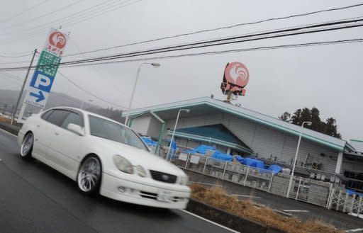 A car goes past a closed home center in Iitate, Fukushima Prefecture. Some 6,000 residents were forced to flee Iitate after radioactive dust from the crippled Fukushima Daiichi nuclear plant fell on this once idyllic farming village, leaving behind houses and shops that were once the focus of village life