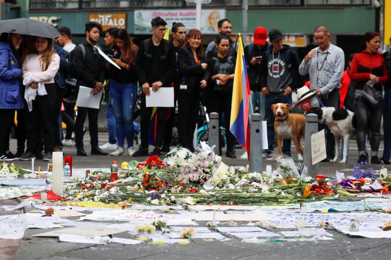 People gather around placards, candles and flowers to honour Dilan Cruz, a teenage demonstrator who died after being injured by a tear gas canister during an initial strike last week, in Bogota