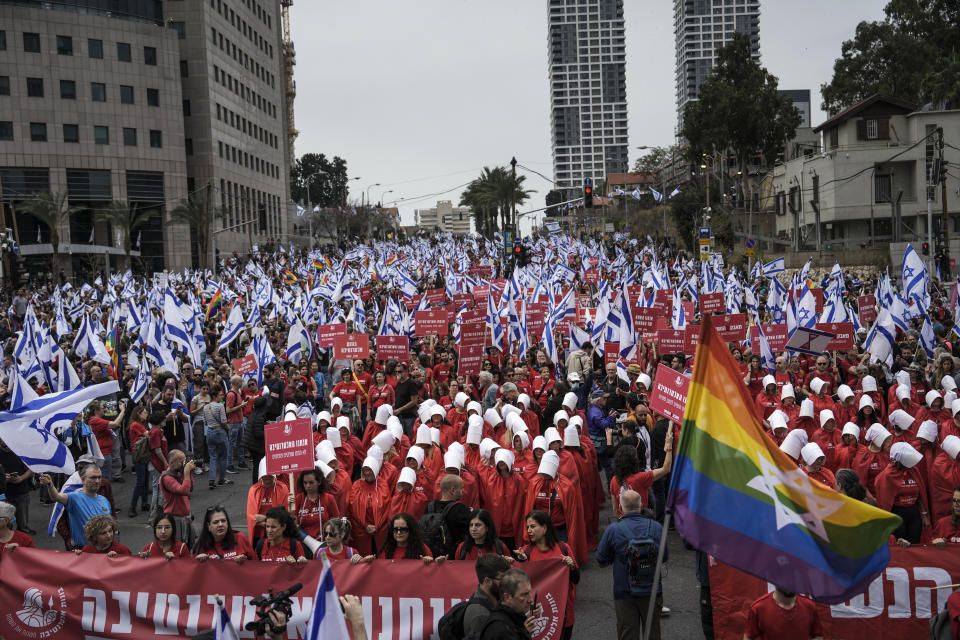 Protesters supporting women's rights dressed as characters from The Handmaid's Tale TV series protest against plans by Prime Minister Benjamin Netanyahu's government to overhaul the judicial system in Tel Aviv, Israel, Thursday, March 23, 2023. (AP Photo/Oded Balilty)