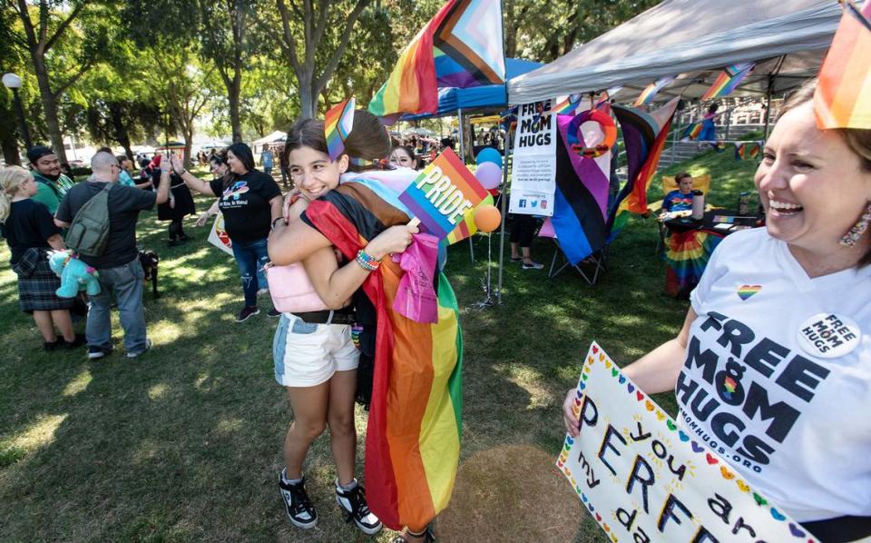 Myranda Ables, 12, gets a hug from Free Mom Hugs organizer Jennifer McQueen, middle, during the MoPride festival at Graceada Park in Modesto, Calif., Saturday, Oct. 1, 2022. Andy Alfaro/aalfaro@modbee.com