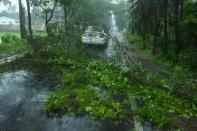 A car drives past fallen tree branches along a road ahead of the expected landfall of cyclone Amphan in Digha, West Bengal on May 20, 2020. (Photo by Dibyangshu SARKAR / AFP)