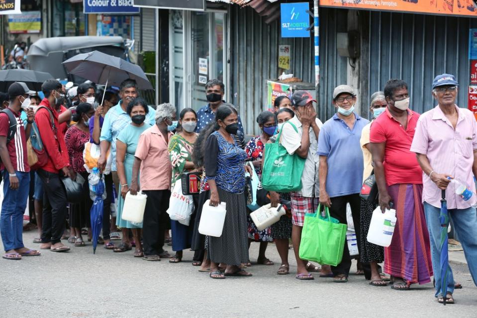 Sri Lankans wait in fuel lines.