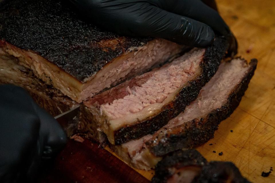 DemKota brisket is sliced for a customer at Tropical BBQ Market.