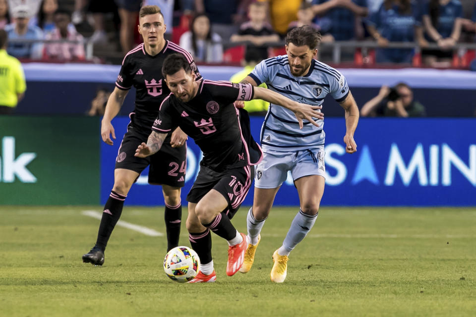 Inter Miami forward Lionel Messi (10) attempts to bypass Sporting Kansas City defender Tim Leibold, right, during the first half of an MLS soccer match Saturday, April 13, 2024, in Kansas City, Mo. (AP Photo/Nick Tre. Smith)