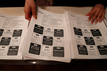 A staff member prepares leaflets of election campaign pledges before a news conference by Tokyo Governor Yuriko Koike, head of Japan's Party of Hope, for it's unveiling in Tokyo, Japan October 6, 2017. REUTERS/Issei Kato